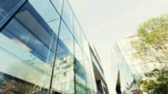 Low-angle view of commercial buildings surrounded by greenery