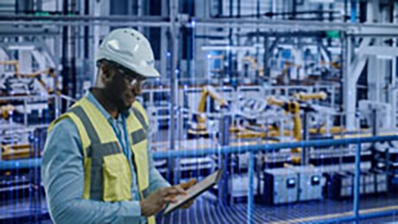 Johnson Controls technician using a tablet in a room with HVAC equipment