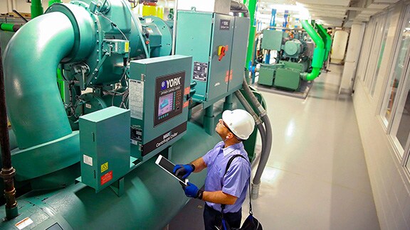 Man with Tablet checking Machine Functions.