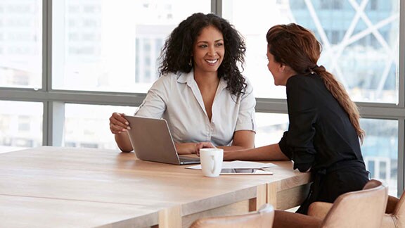 two women in discussion at a conference table 