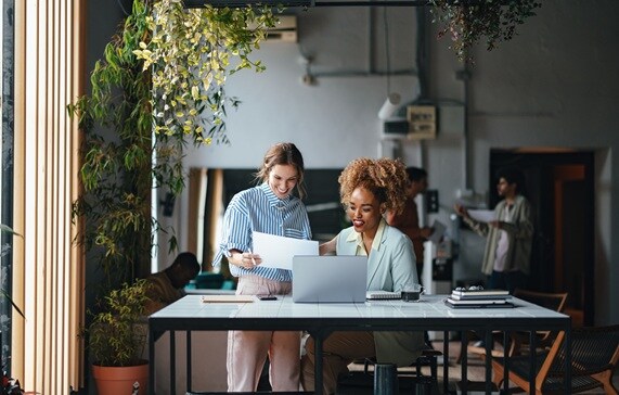 Two people discussing work sitting at a table in a cafe