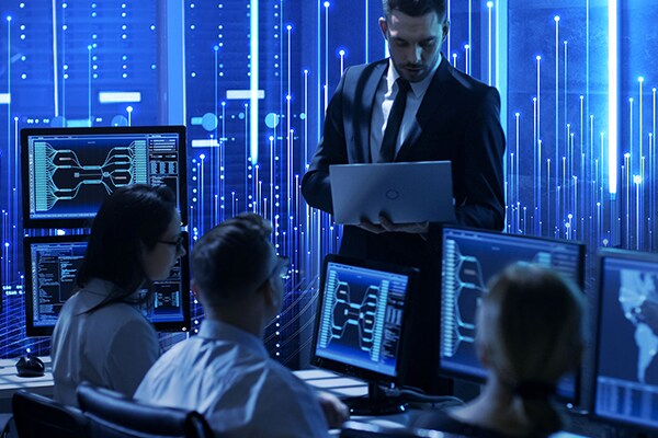 Employees working on their desktops in a control room