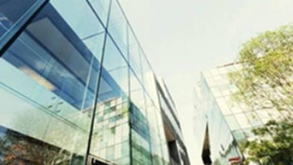 Low-angle view of commercial buildings surrounded by greenery