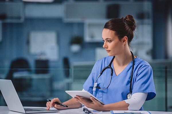 healthcare worker with pen laptop