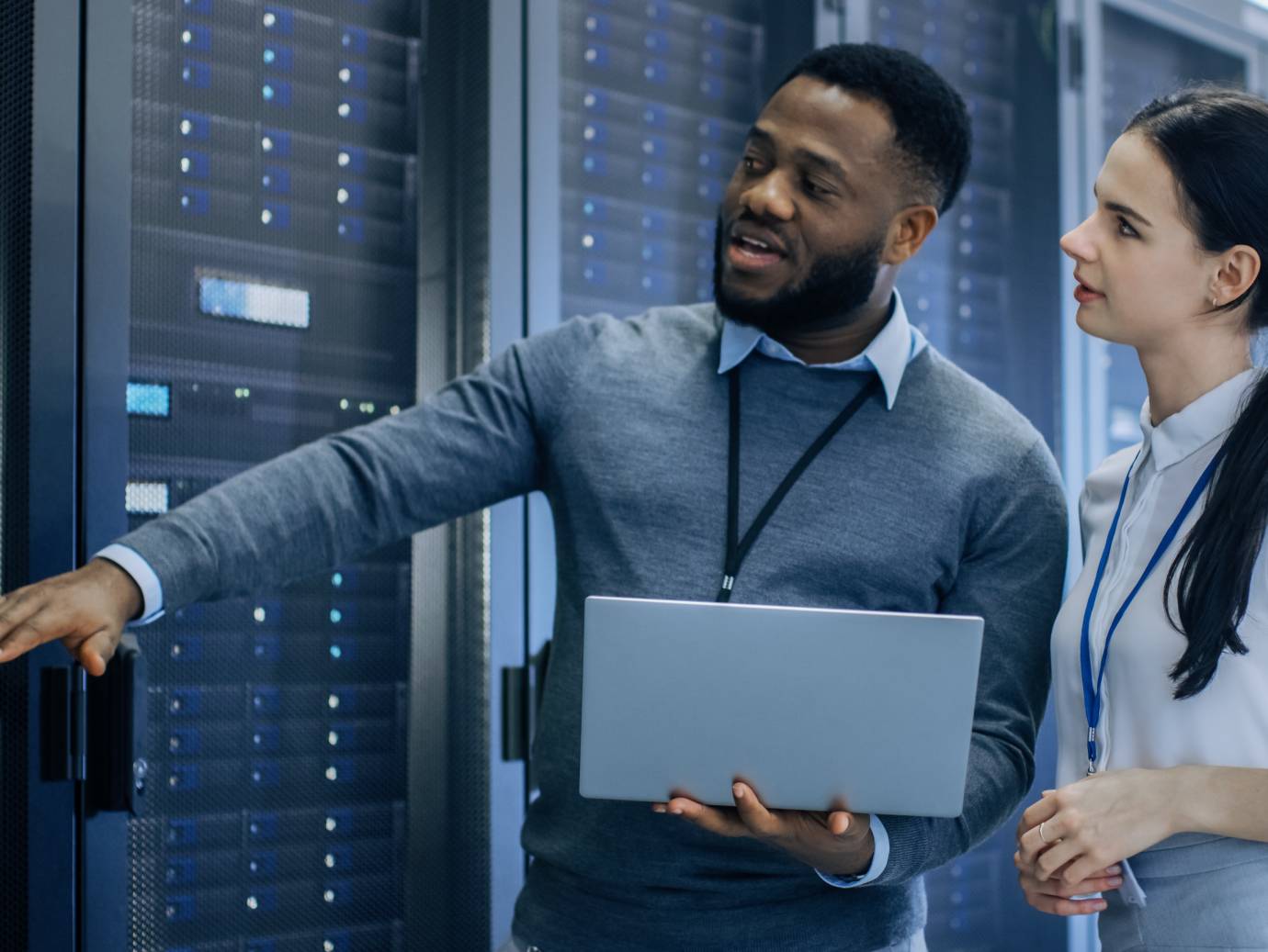 A person and person standing in a room with a computer