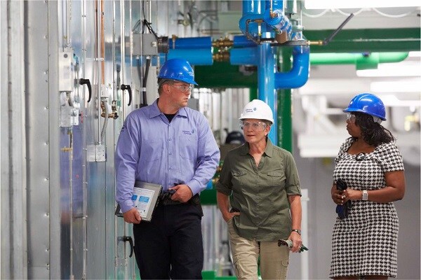 Johnson Controls employees walking in front of machines conversing
