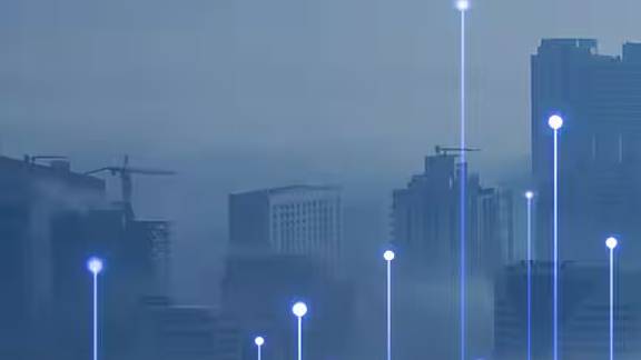 A foggy cityscape overlaid with graphics of transmission nodes.