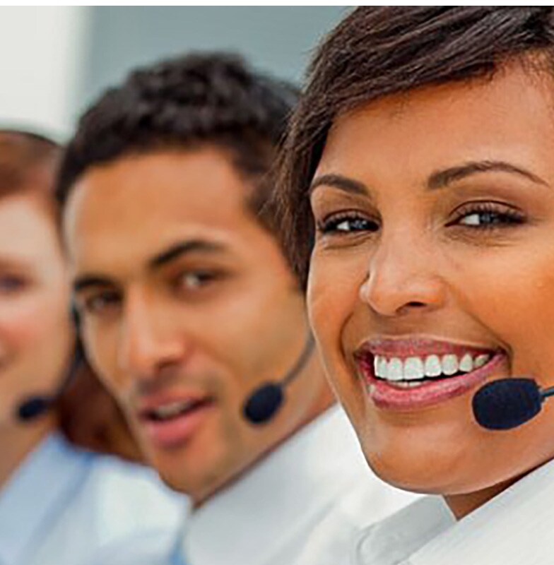 Four people wearing headphones with microphones looking into the camera