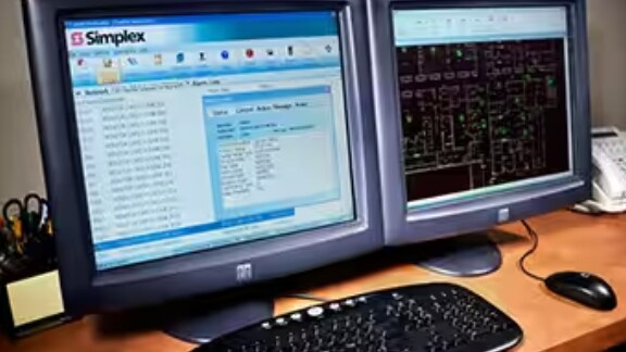Two computer monitors displaying a Simplex portal and a map of ductwork