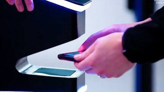 Close-up of a person scanning a cellphone at a security kiosk