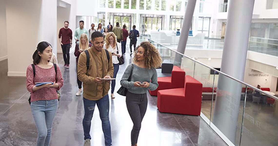 Students talking and walking through a university hallway