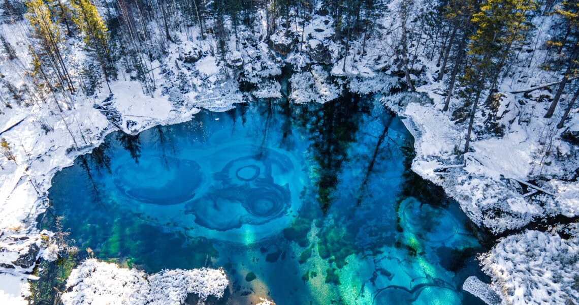 A frozen lake in a snow-covered forest 