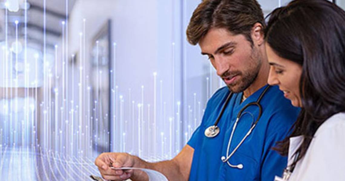 A male surgeon and a female doctor reading reports on a writing pad