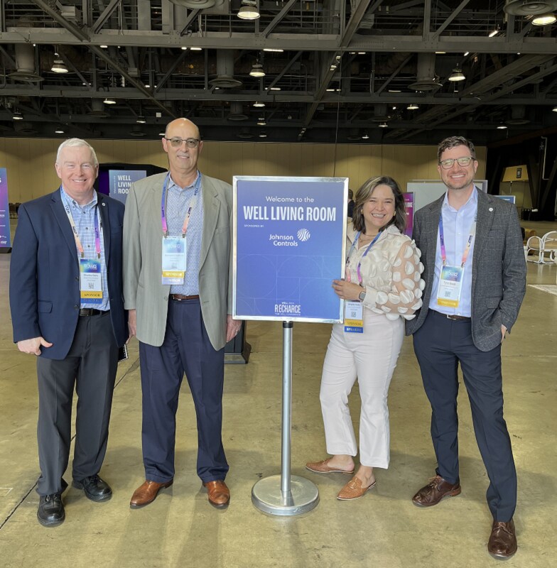 Three man and a woman are standing with a board in the centre