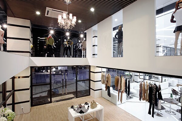 Interior of a shopping mall, with a luxury apparel store in view